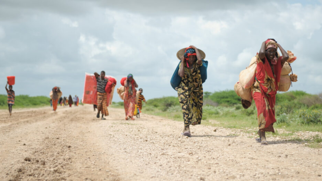 Women, walking with what possesions they can carry, arrive in a steady trickle at an IDP camp erected next to an AMISOM military base near the town of Jowhar, Somalia, on November 12. Heavy rains in Somalia, coupled with recent disputes between clans, has resulted in over four thousand IDPs seeking shelter at an AMISOM military base near the town of Jowhar, with more arriving daily. AU UN IST Photo / Tobin Jones. Original public domain image from Flickr